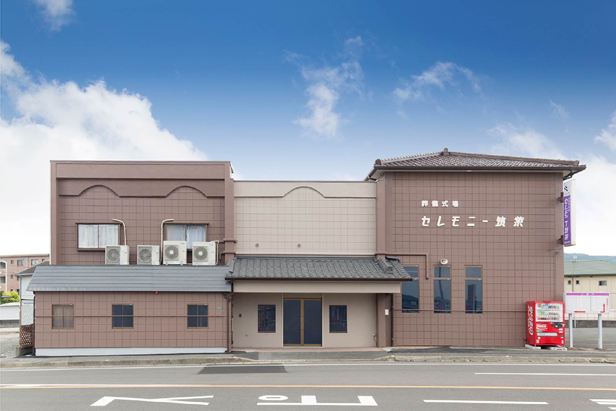 葬儀式場セレモニー筑紫の外観。茶色の建物で紫の看板が目印。